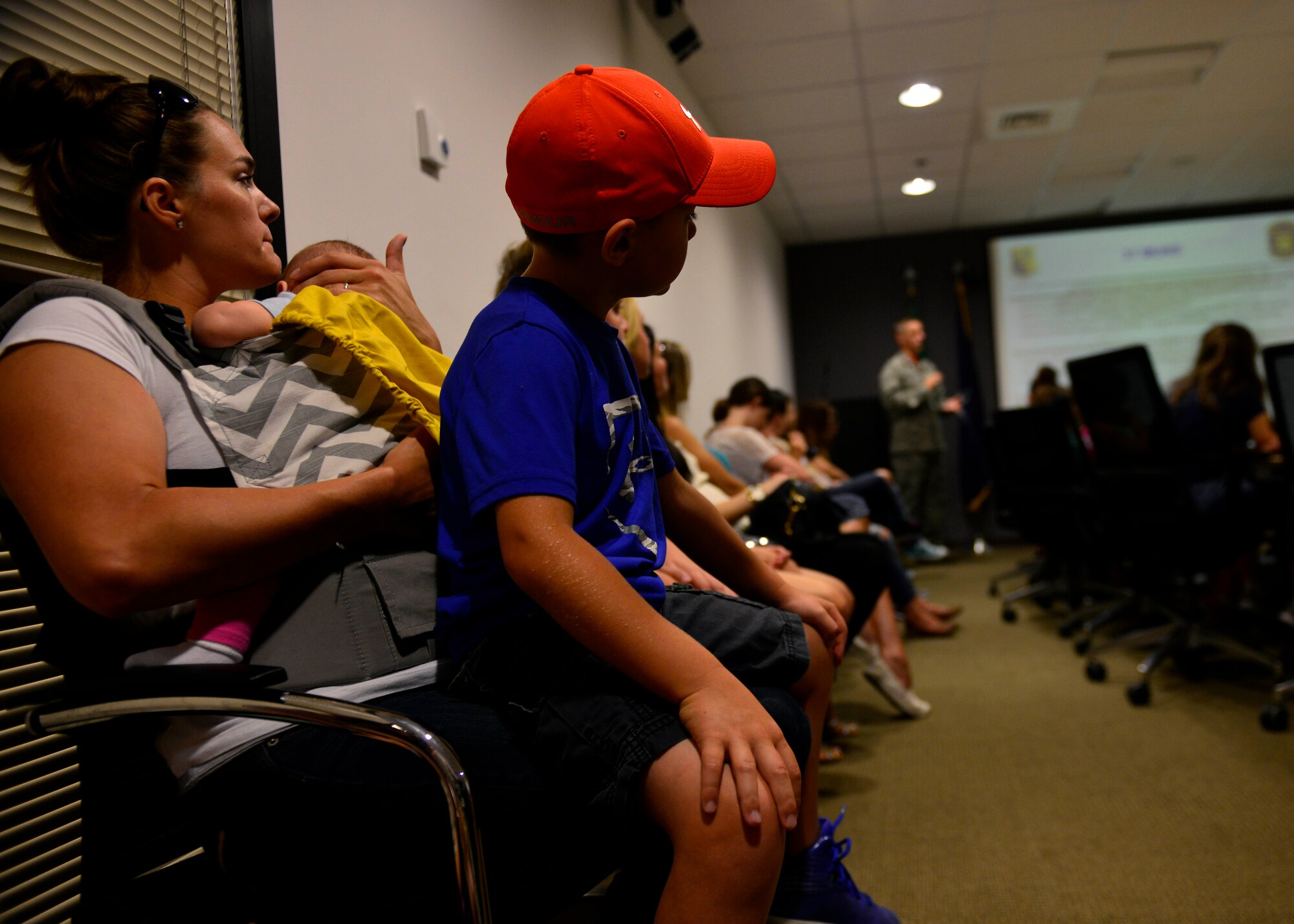 Anna Bledsoe, wife of U.S. Air Force Staff Sgt. Troy Bledsoe, sits with her children during a 31st Munitions Squadron family day mission brief, July 31, 2015, at Aviano Air Base, Italy. The event provided families the opportunity to view munitions equipment and an orientation of work accomplished at the squadron. (U.S. Air Force photo by Airman 1st Class Cary Smith/Released)