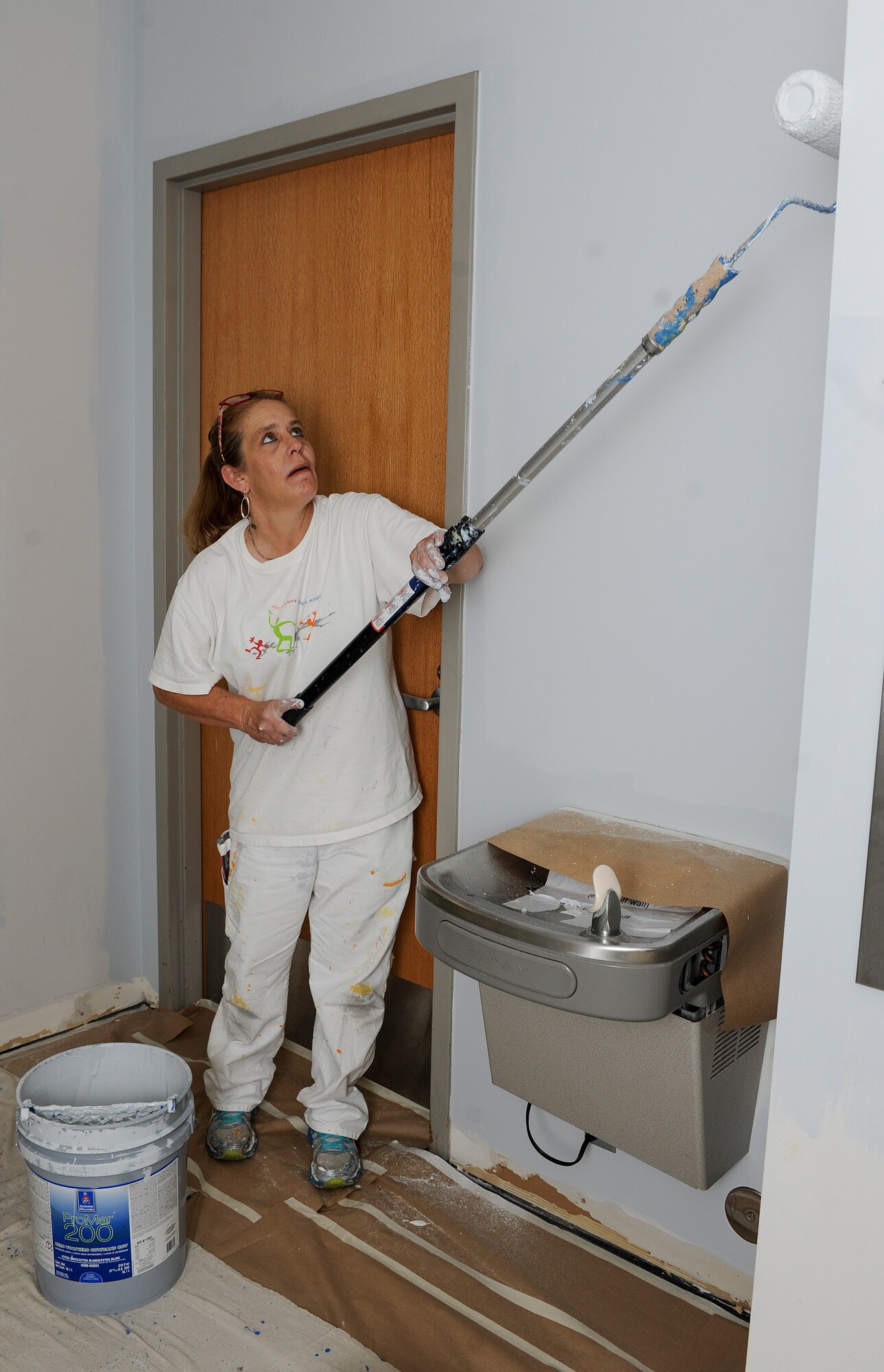 Dona Watson, a contractor, paints a hallway wall in the McAdoo Sports and Fitness Center at Minot Air Force Base, N.D., July 30, 2015. Renovations in the facility began June 15, 2015 and are slated for completion September 2015. (U.S. Air Force photo/Senior Airman Stephanie Morris)