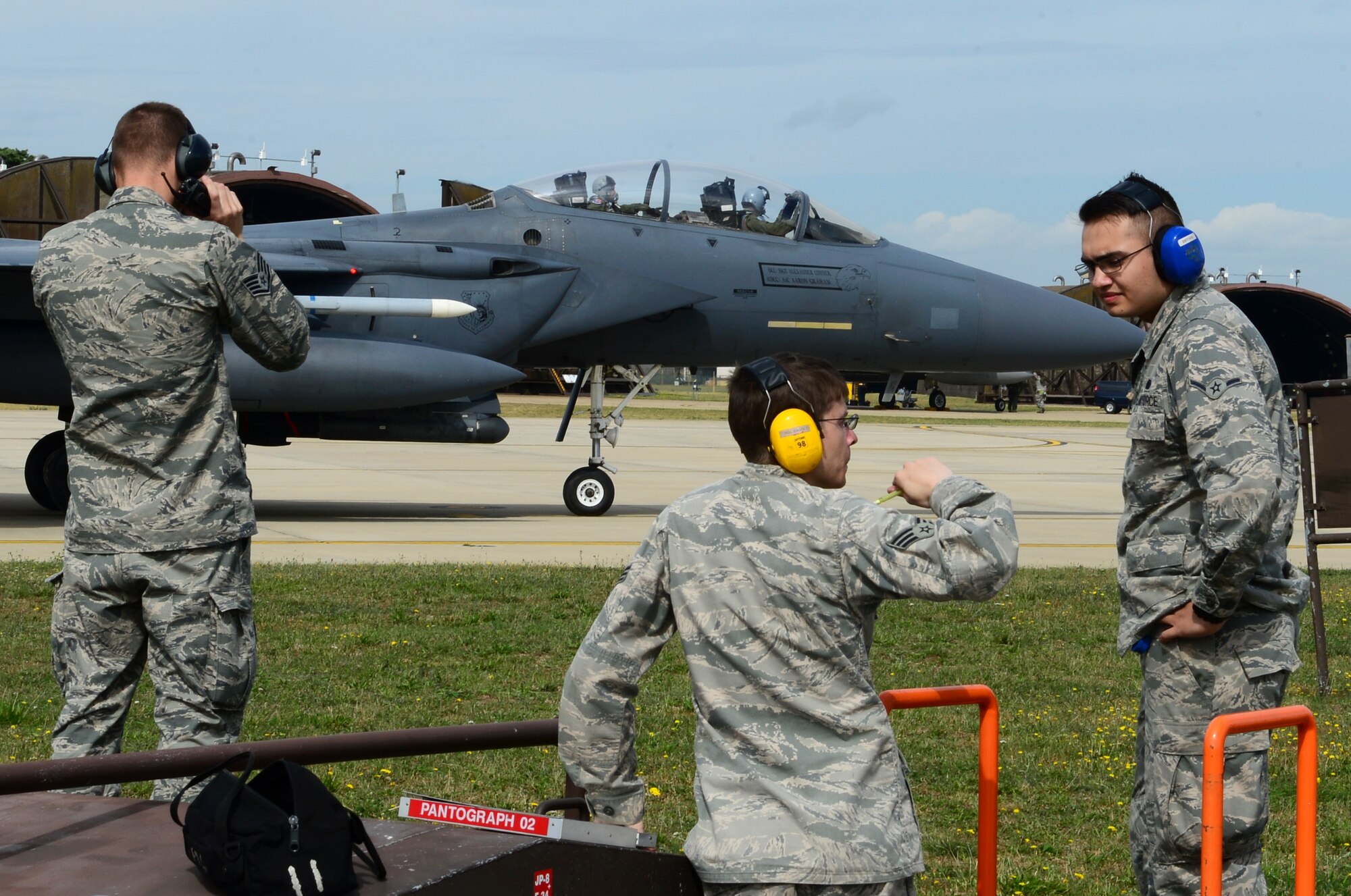Airmen from the 48th Logistics Readiness Squadron Petroleum, Oils and Lubricants prepare an F-15E Strike Eagle to enter the refueling pit at Royal Air Force Lakenheath, England, Aug. 5, 2015. Hot-pit refueling systems give aircraft the ability to land and refuel with engines still running, similar to a stock car making a pit stop in NASCAR. (U.S. Air Force photo by Senior Airman Dawn M. Weber/Released)