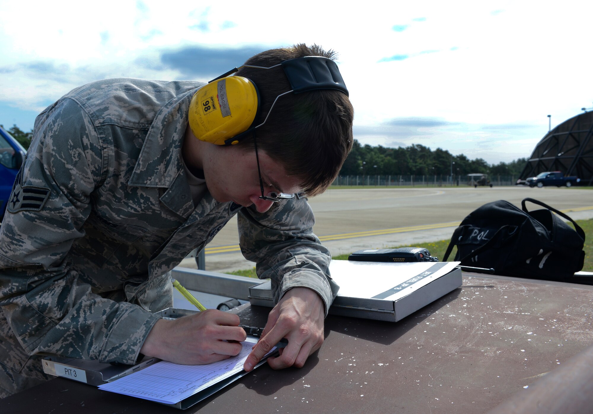 Senior Airman Jason Arms, 48th Logistics Readiness Squadron fixed facilities operator, scribes meter readings during an F-15E Strike Eagle hot-pit refueling at Royal Air Force Lakenheath, England, Aug, 5, 2015. Hot-pit refueling systems give aircraft the ability to land and refuel with engines still running, similar to a stock car making a pit stop in NASCAR. (U.S. Air Force photo by Senior Airman Dawn M. Weber/Released)