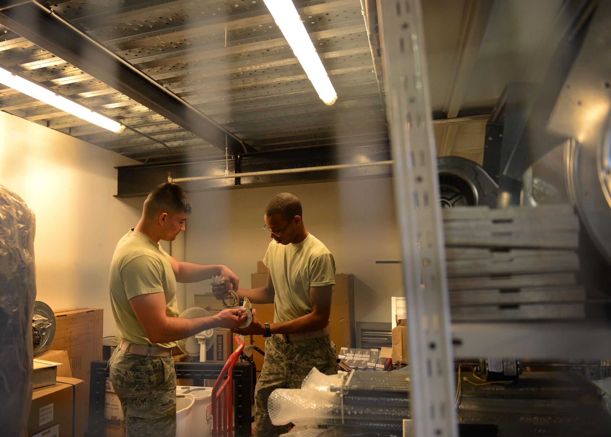 U.S. Air Force Airmen 1st Class Jedadiah Floyd and Jont’e Tate, 31st Civil Engineer Squadron heating, ventilation, air conditioning and refrigeration technicians, assembles a fan coil motor, July 29, 2015, at Aviano Air Base, Italy. The fan coil motor is used for controlling temperatures throughout different rooms in a building. (U.S. Air Force photo by Airman 1st Class Deana Heitzman/Released) 