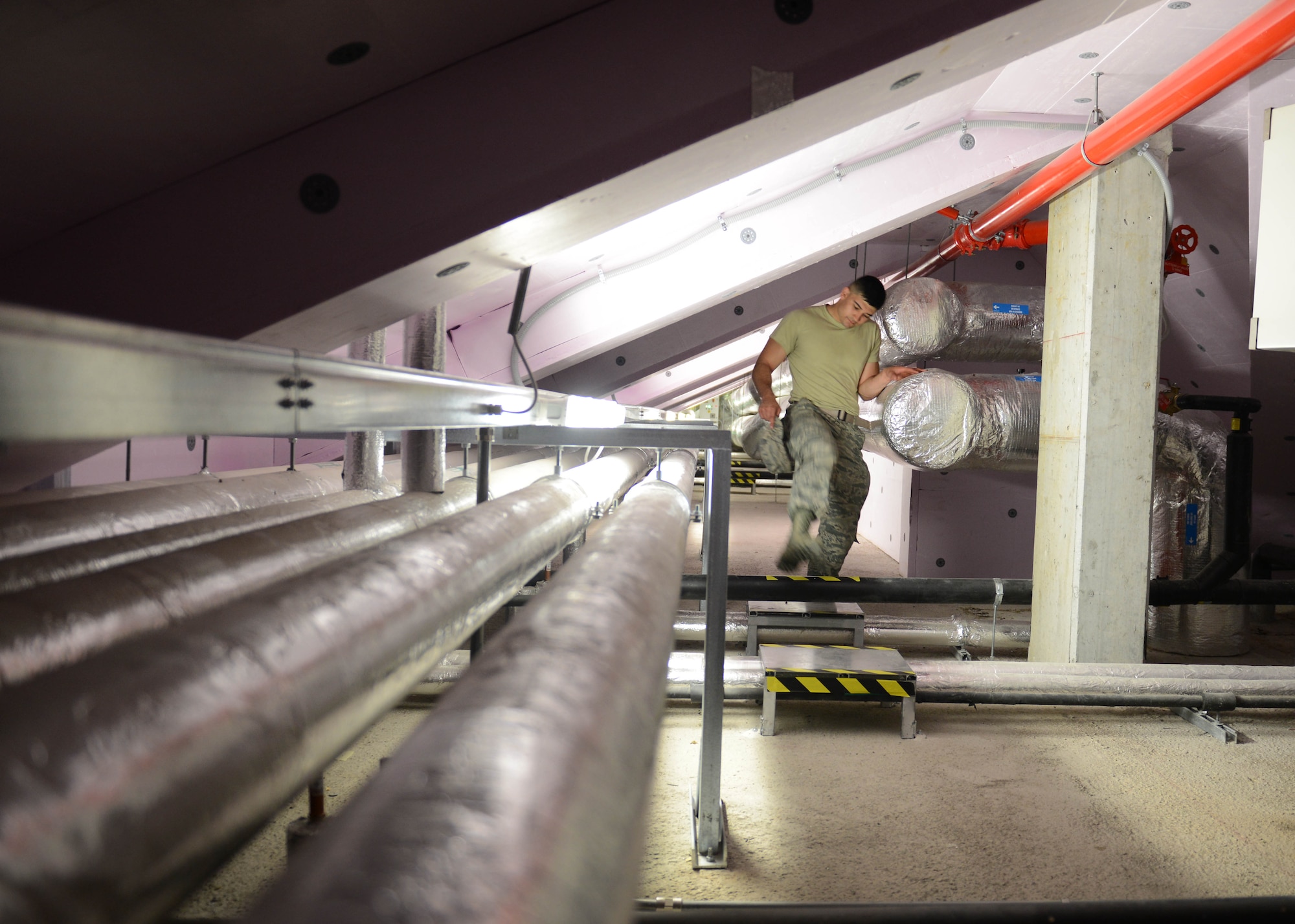U.S. Air Force Airman 1st Class Jedadiah Floyd, 31st Civil Engineer Squadron heating, ventilation, air conditioning and refrigeration technician, walks through a dormitory mechanical room, July 29, 2015, at Aviano Air Base, Italy. Over the summer months, the HVAC shop receives more than 150 work orders a week. (U.S. Air Force photo by Airman 1st Class Deana Heitzman/Released) 