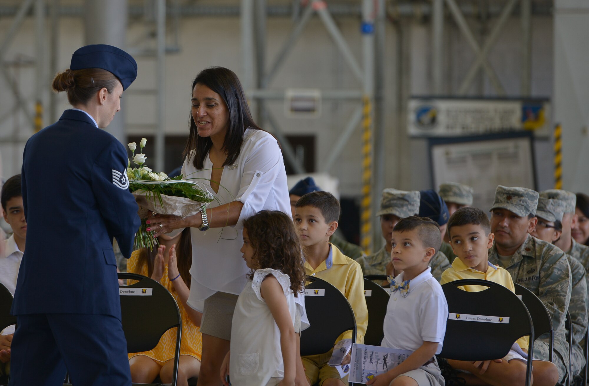 The wife of Col. Gerald A. Donohue, 86th Operations Group commander, accepts a bouquet of flowers during her husband's change of command ceremony Aug. 5, 2015, at Ramstein Air Base, Germany. Donohue took over as the 86th OG commander after Col. Ashley D. Salter to continue supporting the 86th Airlift Wing’s mission by providing full spectrum airlift operations.(U.S. Air Force photo/Airman 1st Class Lane T. Plummer) 
