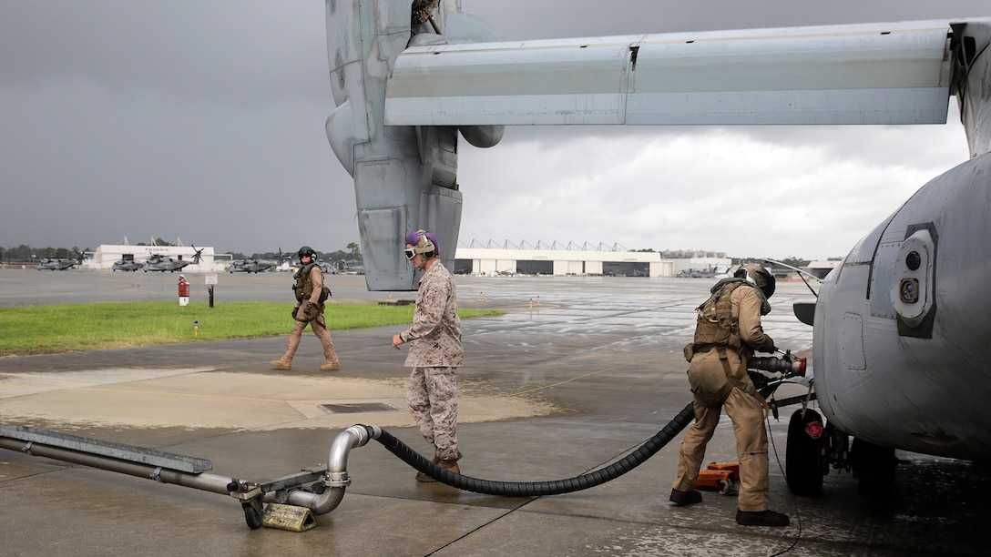 Marines with Marine Medium Tiltrotor Squadron 365, Marine Air Group 26, fuel an MV-22 Osprey aircraft at Marine Corps Air Station New River, North Carolina, before a confined area landing exercise, Aug. 4, 2015. Marines with VMM-365 rehearsed different drop off and extraction scenarios at Landing Zone Bluebird and Landing Zone Bat at Camp Lejeune to maintain skills and standards within the squadron.