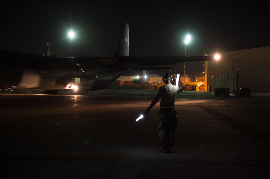 U.S. Air Force Senior Airman Chris Edgington, assigned to the 455th Expeditionary Aircraft Maintenance Squadron, directs a C-130J Super Hercules aircraft on the flight line at Bagram Airfield, Afghanistan, Aug. 7, 2015.  The 455th EAMXS ensure Super Hercules on Bagram are prepared for flight and return them to a mission-ready state once they land. (U.S. Air Force photo by Tech. Sgt. Joseph Swafford/Released) 