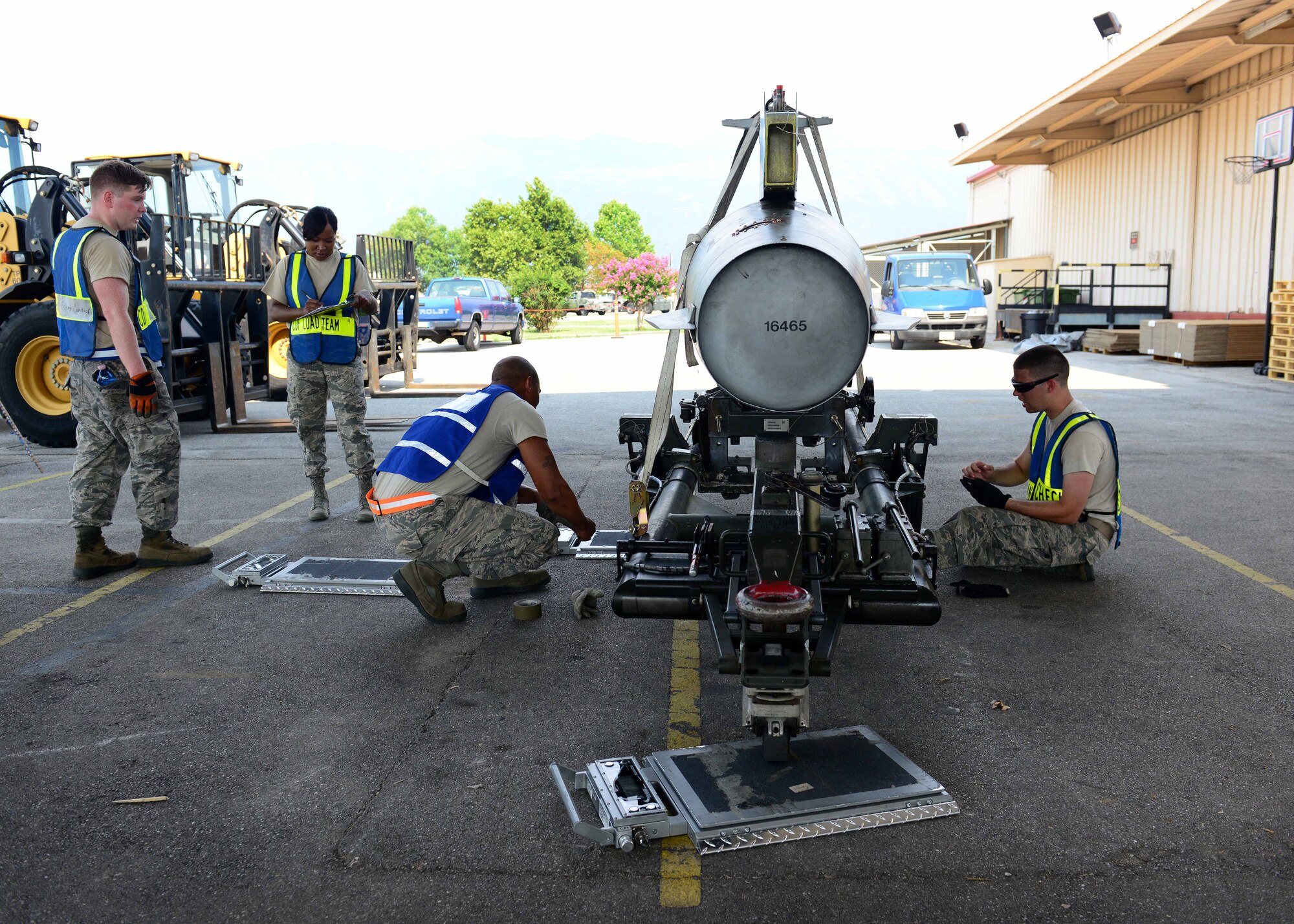 Airmen from the 31st Logistics Readiness Squadron cargo deployment function measure and weigh an excess fuel tank prior to a deployment Aug. 8, 2015, at Aviano Air Base, Italy. This deployment coincides with Turkey's decision to host U.S. aircraft to conduct counter-ISIL operations. (U.S. Air Force photo by Airman 1st Class Deana Heitzman)