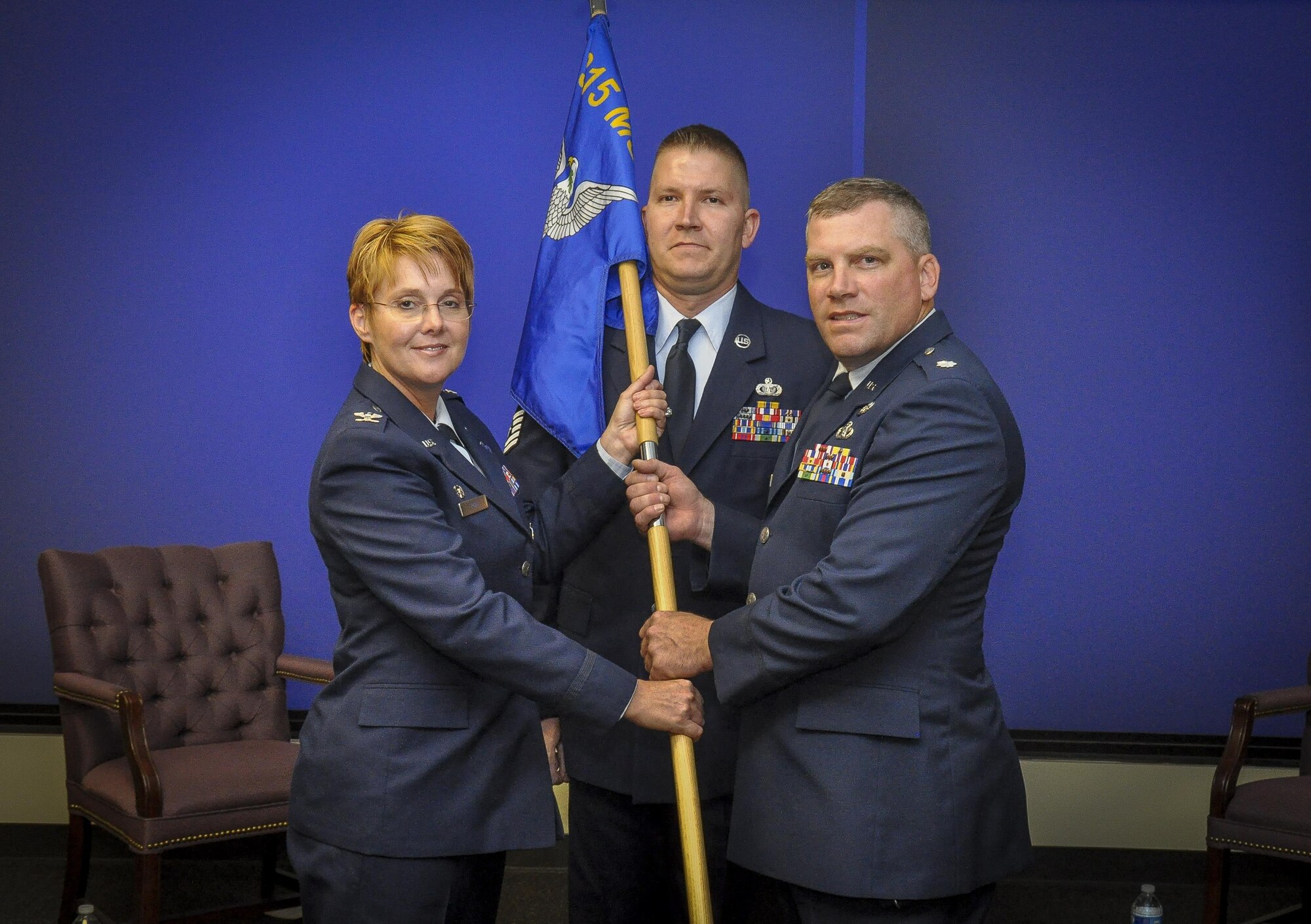 Col. Cherie Roff, 315th AW Mission Support Group commander, passes the guide on to Lt. Col. Garrett Stumb, incoming 315th Civil Engineer Flight commander, during a change of command ceremony Aug. 9, 2015, at Joint Base Charleston, S.C.  (U.S. Air Force photo by Senior Airman Tom Brading)
