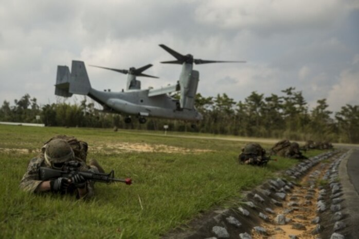 Marines provide perimeter security as an MV-22B Osprey takes off at Camp Hansen, Okinawa, Japan, Aug. 3, 2015. Marines with Marine Wing Support Squadron 172, Engineer Company flew into Landing Zone Buzzard, where they bounded off of the tiltrotor aircraft and provided perimeter security for additional aircraft to land. This training took place during Exercise Beach Fire, a squadron sized exercise designed to increase the overall mission readiness of MWSS 172. The Marines are combat engineers with Engineer Company, MWSS 172, Marine Aircraft Group 36, 1st Marine Aircraft Wing, III Marine Expeditionary Force.