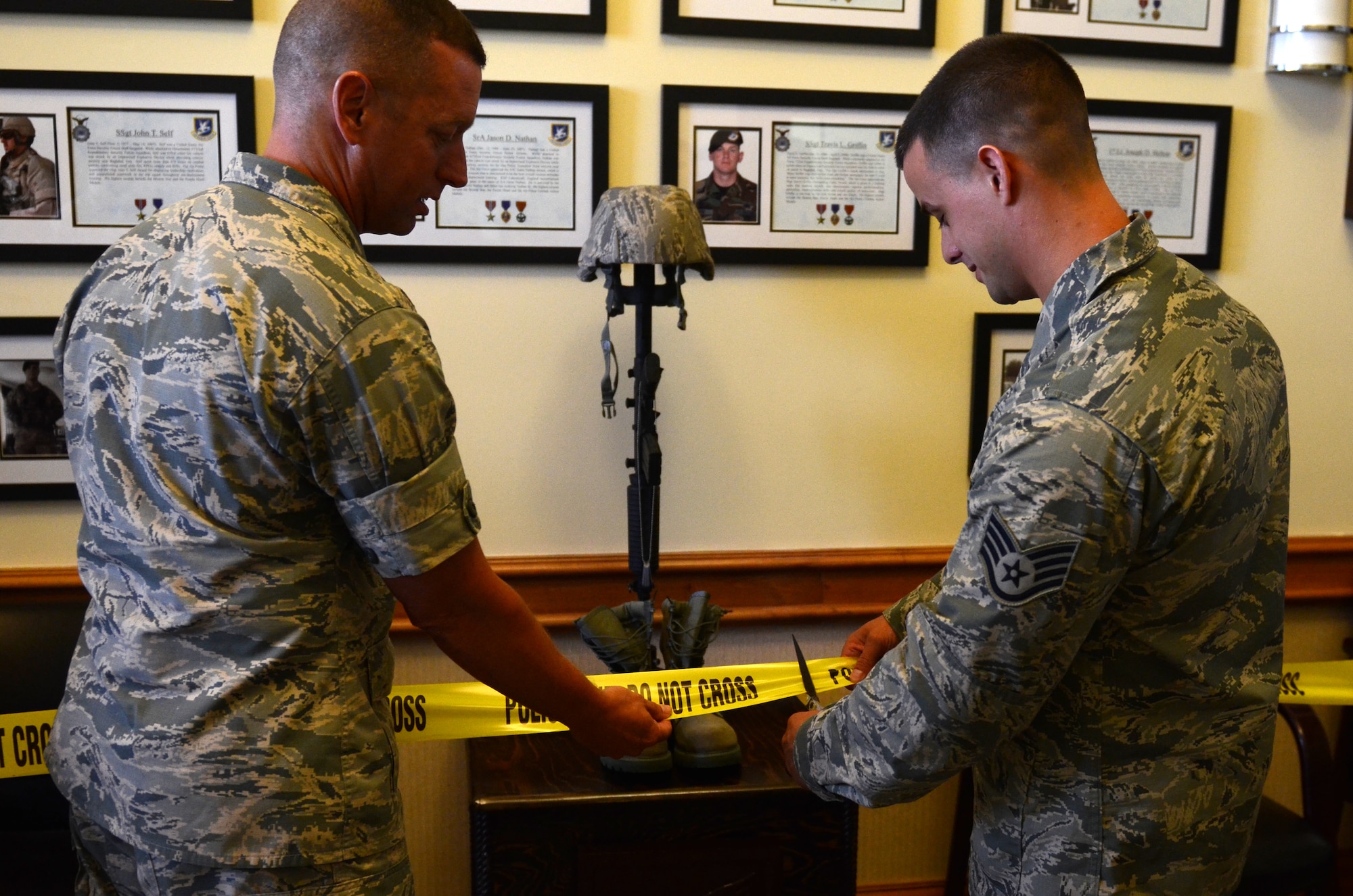Maj. Mike Jewell, 36th Security Forces Squadron commander, left, and Staff Sgt. Scott Ray, 36th SFS assistant flight chief, cut the tape to unveil a new memorial Aug. 6, 2015, at Andersen Air Force Base, Guam. The memorial honors the 10 defenders who lost their lives in Operation Iraqi Freedom and Operation Enduring Freedom. (U.S. Air Force photo by Airman 1st Class Alexa Ann Henderson/Released)
