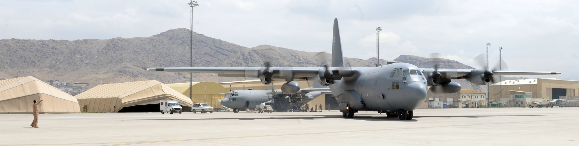 An Afghan air force crew chief marshals a C-130H to the flight light July 28, 2015, at Hamid Karzai International Airport. (U.S. Air Force photo by Senior Airman Cierra Presentado)
