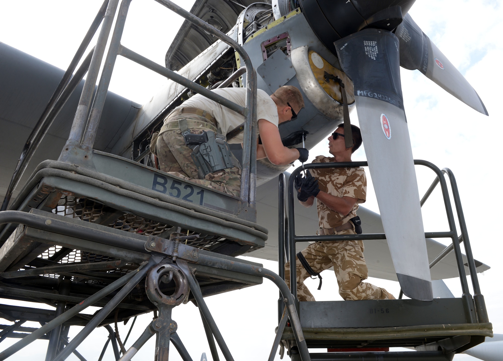 Staff Sgt. Nathanial Weitzell, 440th Air Expeditionary Advisory Squadron C-130 engine mechanic, removes the engine chin scoop panel for an inspection with a Romanian air force mechanic July 28, 2015, at Hamid Karzai International Airport.  Weitzell is deployed to Kabul, Afghanistan, from the 911th Maintenance Squadron in Pittsburgh, Pennsylvania. He is part of the Train, Advise, Assist Command-Air (TAAC-Air) unit that works shoulder-to-shoulder with Afghan partners to develop a professional, capable, and sustainable Air Force. (U.S. Air Force photo by Senior Airman Cierra Presentado)