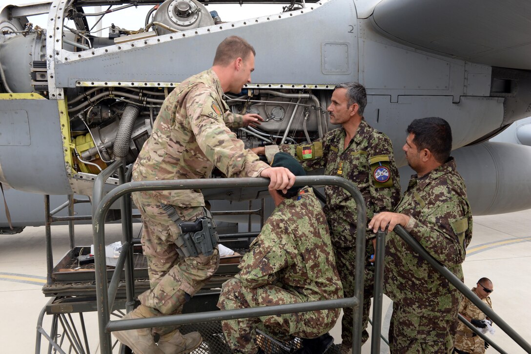 Master Sgt. Antonio Policicchio, 440th Air Expeditionary Advisory Squadron C-130 engine mechanic, discusses the engine bleed air system and changing the speed sensitive valve filter with Afghan air force mechanics July 28, 2015, at Hamid Karzai International Airport.  Policicchio is deployed to Kabul, Afghanistan, from the 911th Maintenance Squadron in Pittsburgh, Pennsylvania. He is part of the Train, Advise, Assist Command-Air (TAAC-Air) unit that works shoulder-to-shoulder with Afghan partners to develop a professional, capable, and sustainable Air Force.  (U.S. Air Force photo by Senior Airman Cierra Presentado)