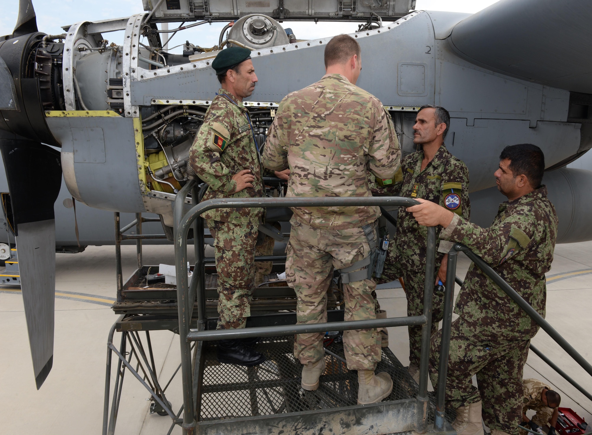 Master Sgt. Antonio Policicchio, 440th Air Expeditionary Advisory Squadron C-130 engine mechanic, discusses the engine bleed air system and changing the speed sensitive valve filter with Afghan air force mechanics July 28, 2015, at Hamid Karzai International Airport.  Policicchio is deployed to Kabul, Afghanistan, from the 911th Maintenance Squadron in Pittsburgh, Pennsylvania. He is part of the Train, Advise, Assist Command-Air (TAAC-Air) unit that works shoulder-to-shoulder with Afghan partners to develop a professional, capable, and sustainable Air Force. (U.S. Air Force photo by Senior Airman Cierra Presentado)