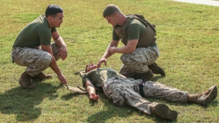 Petty Officer 3rd Class James Hyles (left), a Combat Lifesaver instructor with Weapons Company, 2nd Battalion, 2nd Marine Regiment, explains to a student how to keep the victim stable during the practical application portion of the Combat Lifesaver course at Marine Corps Base Camp Lejeune, N.C., Aug. 6, 2015. The three-day CLS course consisted of classroom instruction and practical application that included treating serious wounds that could occur in a combat situation. 