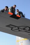 Air Force Tech. Sgt. Mike Konegni, Air Force Airman Travis Maderand and Air Force Airman 1st Class Colton Shirley, with the Wyoming Air National Guard's 153rd Aircraft Maintenance Squadron, place orange tape on a C-130 Hercules cargo plane identified for an aerial firefighting mission in the western portion of the United States, Sept. 8, 2011. The tape helps other aircraft identify the plane as part of the coordinated firefighting efforts. The C-130 uses the Modular Airborne Firefighting System II, to battle the wildfires. Two C-130s and 30 Airmen, from the Wyoming Air National Guard, will be based in Boise, Idaho, to fight fires in Nevada, Utah and Idaho. The 153rd Airlift Wing is one of four Air National Guard and Air Force Reserve units assigned MAFFS missions.