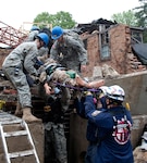 Members of the 53rd Civil Support Team, Indiana National Guard, join efforts with the Indiana Department of Homeland Security tactical rescue team to pull a mock victim from the rubble during National Level Exercise 2011 at the Muscatatuck Urban Training Complex, Ind., May 16, 2011. NLE 2011 was a full-scale exercise meant to represent the destruction following a 7.7 magnitude earthquake along the New Madrid fault line and examined the government's ability to implement local, state, and federal catastrophic earthquake response plans. The National Guarded coordinated response efforts with U.S. Northern Command and federal, state and local agencies throughout the exercise.