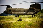 Two Soldiers with the Army Reserve’s 739th Engineer Company, Indiana National Guard, hook a sling to the bottom of an Illinois Army National Guard CH-47 Chinook helicopter Sept. 11, 2011, during a joint-service, sling-load training mission at the Sparta Training Area, Ind. The training brought Guard and reserve component Soldiers, Sailors, Marines and Airmen for one day of classroom and field training. 