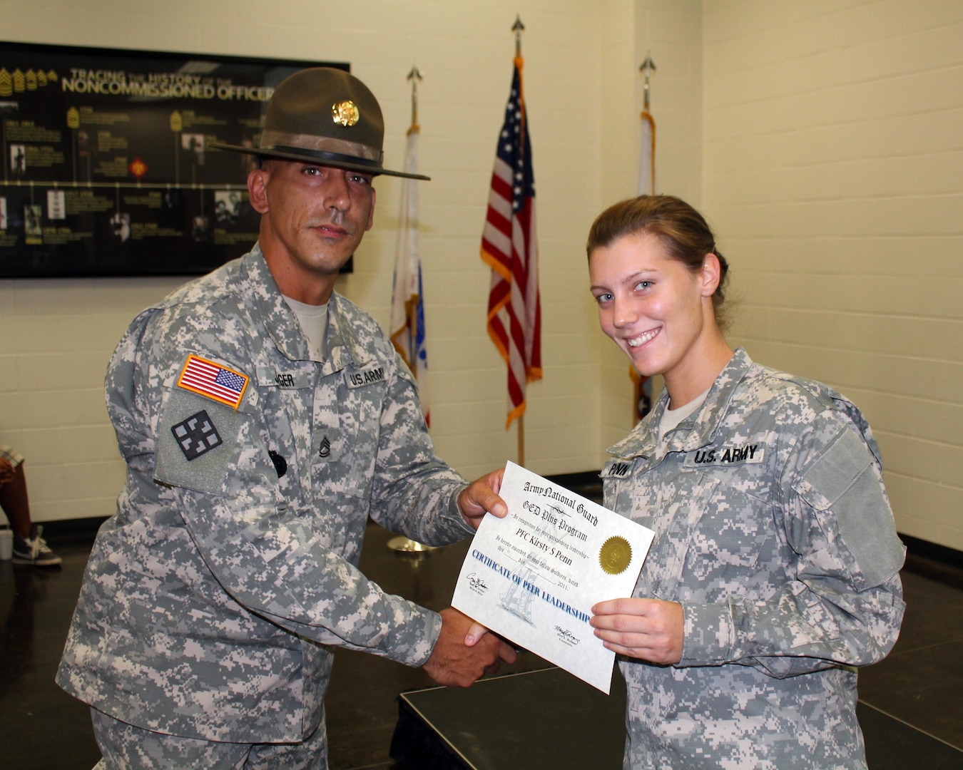 Army Pfc. Kirsty Penn receives a Class Peer Leader Certificate from Army Drill Sgt. Eric Jaeger, Sept. 9, 2011, at Camp Robinson in North Little Rock, Ark. Penn was the first female recruit to receive the honor as Class Peer Leader in the program's history. Since 2006, the National Guard GED Plus program has conferred more than 13,000 GED diplomas to Soldiers nationwide.