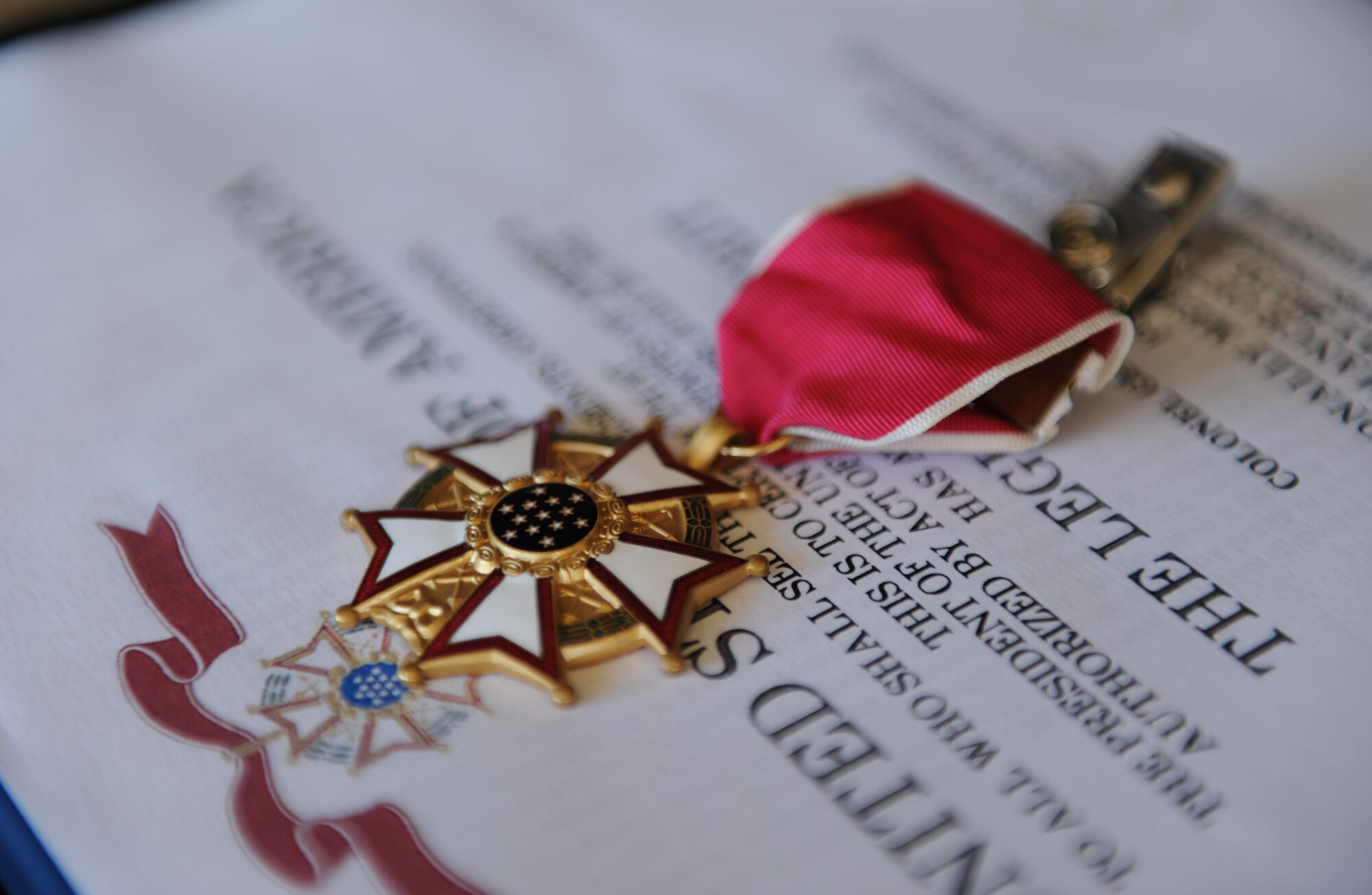 A Legion of Merit medal and certificate sit on display to be presented to Col. George Tombe, outgoing 81st Training Group commander, during a change of command ceremony, August 7, 2015, Keesler Air Force Base, Miss.  Col. Michele Edmondson, 81st Training Wing commander, was the officiating officer for the ceremony. (U.S. Air Force photo by Kemberly Groue)