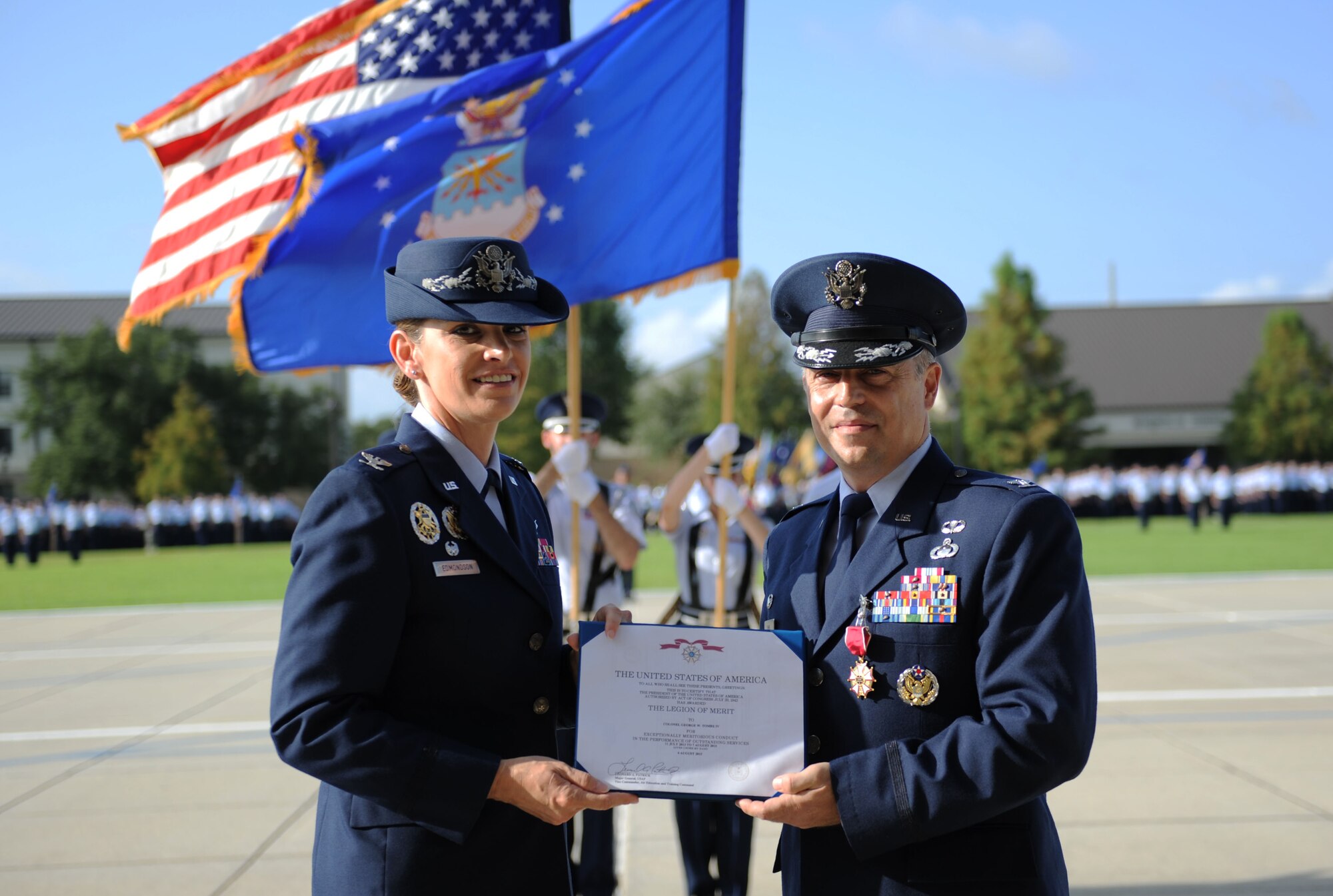Col. Michele Edmondson, 81st Training Wing commander, presents the Legion of Merit certificate to Col. George Tombe, outgoing 81st Training Group commander, during a change of command ceremony, August 7, 2015, Keesler Air Force Base, Miss.  Col. Tombe has been selected to serve as the financial management and comptroller director at Headquarters USAFE-AFAFRICA. (U.S. Air Force photo by Kemberly Groue)
