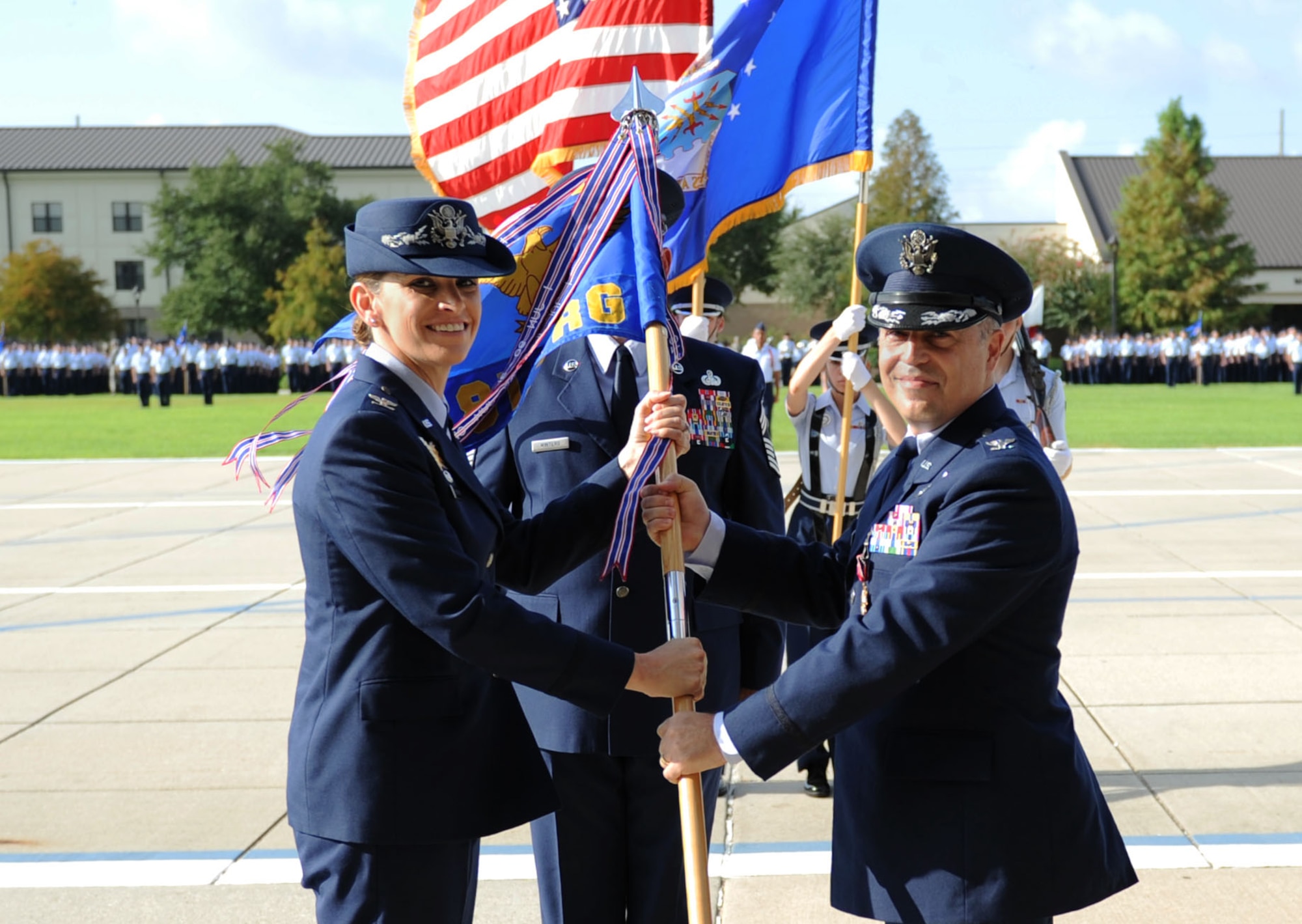Col. Michele Edmondson, 81st Training Wing commander, takes the guidon from Col. George Tombe, outgoing 81st Training Group commander, during a change of command ceremony, August 7, 2015, Keesler Air Force Base, Miss. The guidon ceremony is a symbol of command being exchanged from one commander to the next. Col. Tombe has been selected to serve as the financial management and comptroller director at Headquarters USAFE-AFAFRICA. (U.S. Air Force photo by Kemberly Groue)