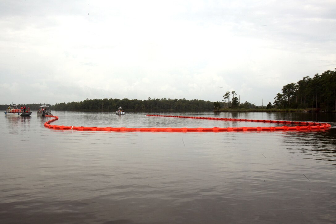 Two response boats collect simulated oil using a boom during a facility response training exercise conducted to ensure top performance in the possible situation of an oil spillage at Marine Corps Air Station Cherry Point, North Carolina, Aug. 4, 2015. Typically referred to as Open Water Spill Team Training, the annual training is mandatory under federal and state laws such as the Clean Water Act and the Oil Pollution Act of 1990. Spill response measures are put into place to provide control, containment and cleanup in order to prevent injury and damage to personnel, property, and the environment.