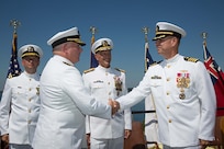 Rear Adm. Michael Jabaley (second from left) shakes hands with Rear Adm. (select) Moises DelToro (right) as they pass command of NUWC from Jabaley to DelToro at a ceremony held at Division Newport on July 31. Looking on are Vice Adm. William Hilarides (second from right), commander, NAVSEA  and Lt. Philip Carson (left), Naval Station Newport chaplain.