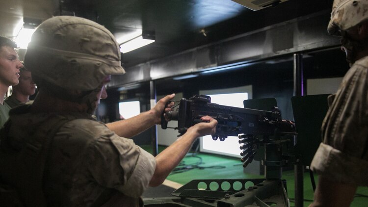 A Marine with Weapons Company, 2nd Battalion, 2nd Marine Regiment, racks the bolt of an M2 50-caliber machine gun back during training at the Indoor Simulated Marksmanship Trainer at Marine Corps Base Camp Lejeune, N.C., Aug. 5, 2015. Although the ISMT weapons are powered by compressed air, misfires with real weapons are obstacles Marines must learn to overcome quickly. 
