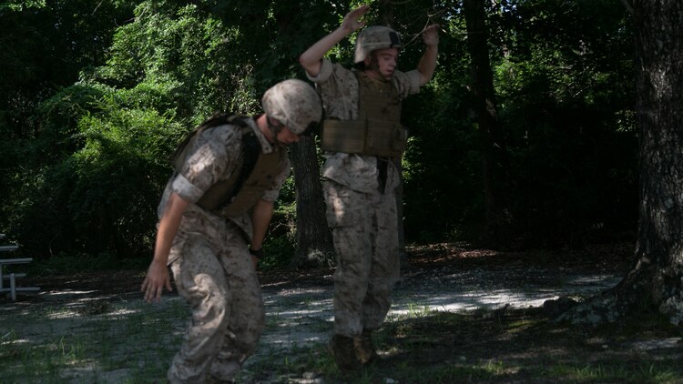 Marines with Weapons Company, 2nd Battalion, 2nd Marine Regiment, perform burpees during training at the Indoor Simulated Marksmanship Trainer at Marine Corps Base Camp Lejeune, N.C., Aug. 5, 2015. The Marines conducted physical exercises during the training to increase heart rates, fatigue and stress in order to add to the realism of the simulations. 
