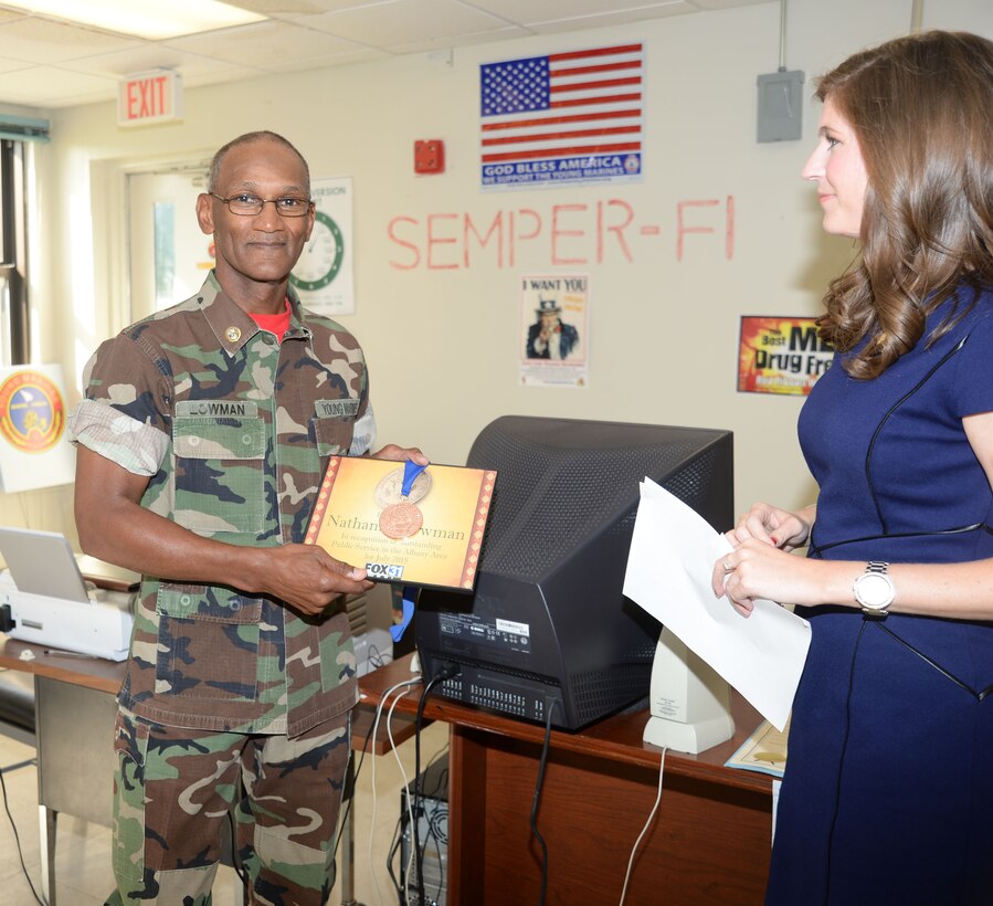 Retired Marine Corps Master Sgt. Nathaniel Lowman receives the Thomas Jefferson Community Service Award from Tracey Smith, news anchor/reporter, Fox 31 News, Albany, Ga. The award was presented to Lowman for his work with the Young Marines of Albany and in the community during a ceremony held at the Young Marines of Albany headquarters, Marine Corps Logistics Base Albany, Aug. 5.