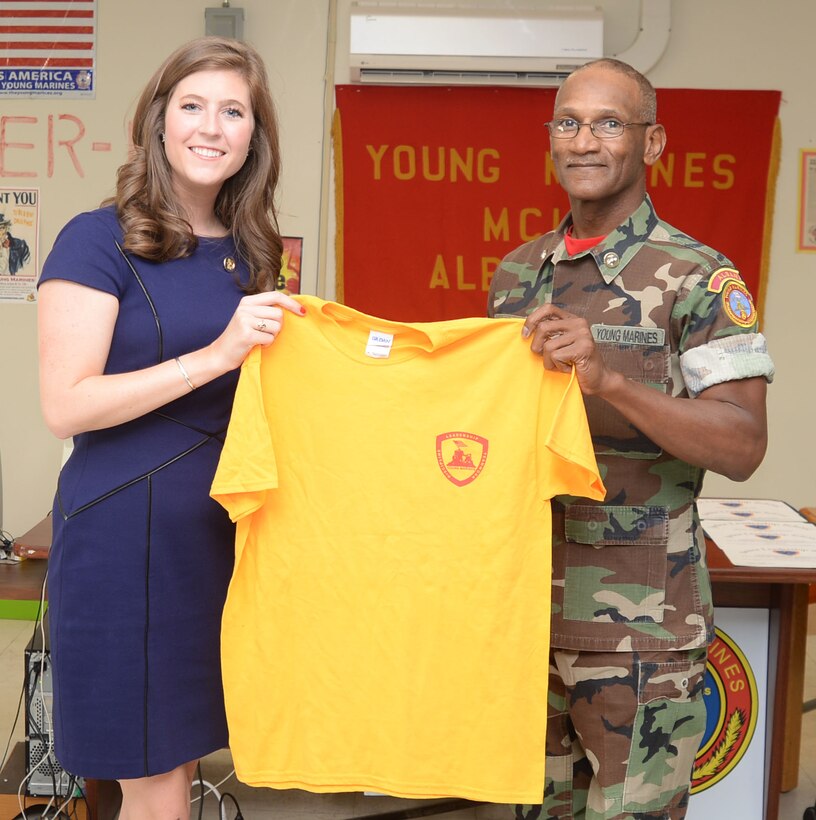 Retired Marine Corps Master Sgt. Nathaniel Lowman presents Tracey Smith, news anchor/reporter, Fox 31 News, Albany, Georgia, a Young Marines of Albany T-shirt. Smith had presented Lowman the Thomas Jefferson Community Service Award in a ceremony held at the Young Marines of Albany headquarters, Marine Corps Logistics Base Albany, Aug. 5.
