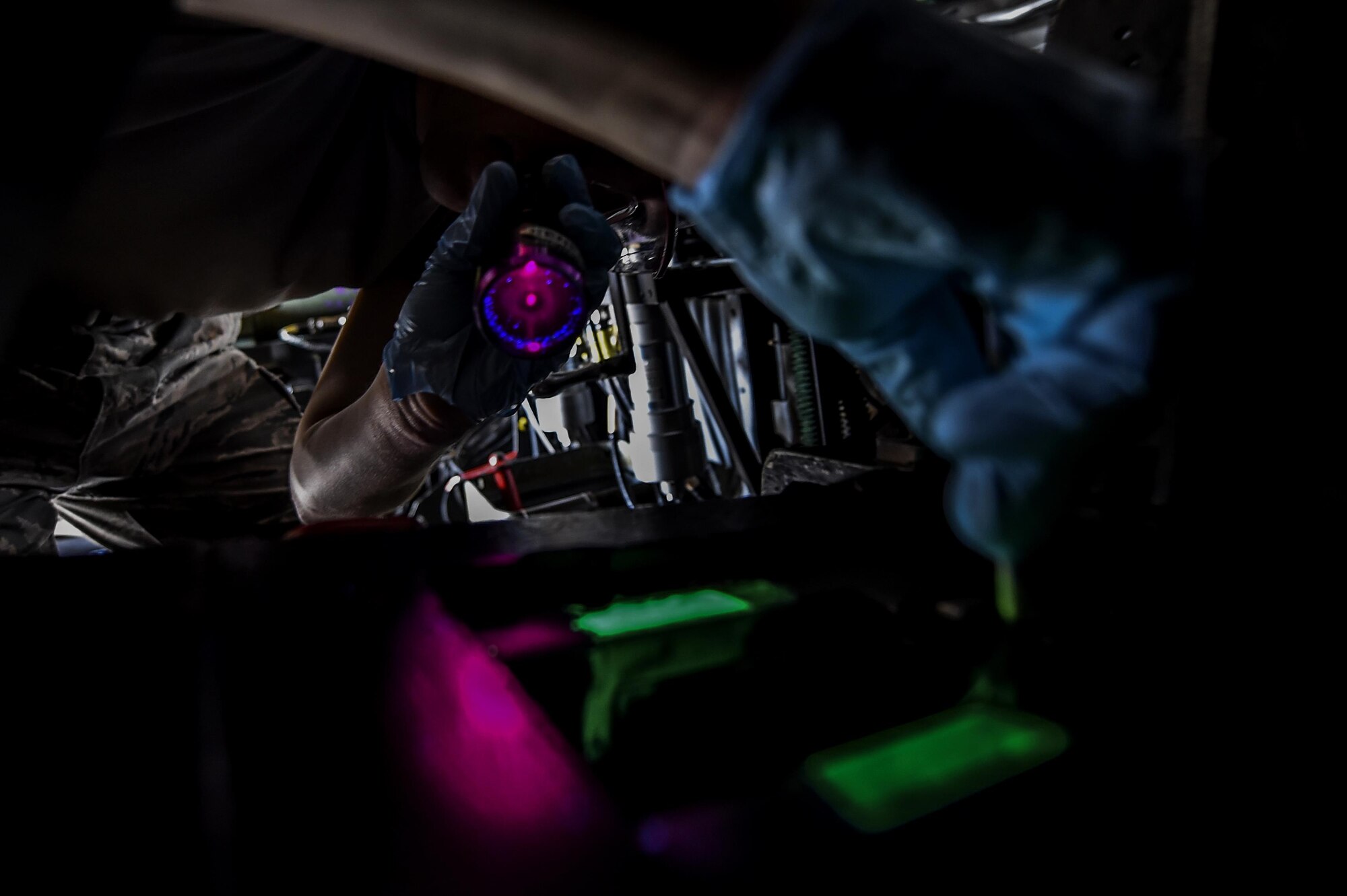 Airmen with the 1st Special Operations Equipment Maintenance Squadron non-destructive inspection flight use a black light to search for cracks inside a 40mm weapon attached to an AC-130U Spooky Gunship on Hurlburt Field, Fla., July 21, 2015. The NDI flight is responsible for detecting the smallest imperfections, wear and cracks on aircraft as well as aerospace ground equipment. (U.S. Air Force photo/Senior Airman Christopher Callaway)