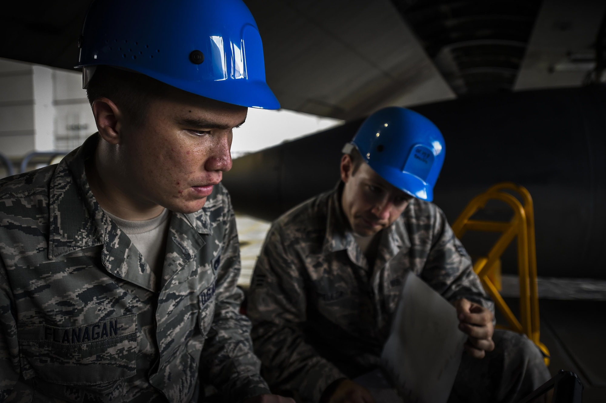 Senior Airman Thomas Speulda, 1st Special Operations Equipment Maintenance Squadron non-destructive inspection journeyman, reviews a technical order with Airman 1st Class Julian Flanagan, 1st SOEMS NDI apprentice, at the Eason Hangar on Hurlburt Field, Fla., July 20, 2015. The technical orders are used to ensure each step of the work process is followed for each and every work order. (U.S. Air Force photo/Senior Airman Christopher Callaway)