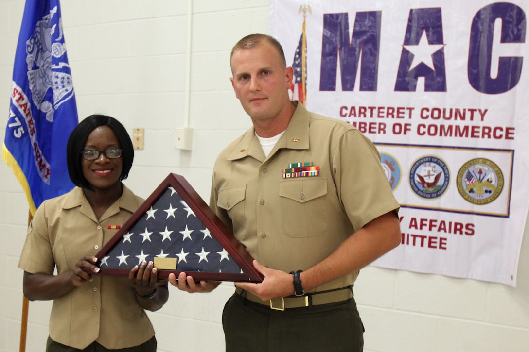 Lance Cpl. Lacey L. Dauphine and Chief Warrant Officer Vincent Steele hold a cased American Flag given to Dauphine during the Service Person of the Quarter luncheon ceremony in Morehead City, North Carolina, Aug. 7, 2015. The Havelock Chamber of Commerce honored Dauphine as the Service Person of the Quarter for performance in her job field, as well as, her off-duty activities. Additionally, two other outstanding service members were recognized for their constant dedication to duty and their community. Dauphine is an administrative specialist and Steele is the inbound personnel officer, both with Headquarters and Headquarters Squadron.