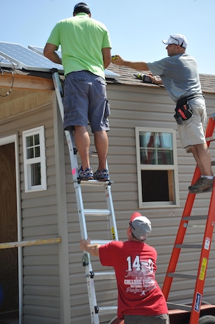 Jeffery Watts, top left, and Dominic Ragucci,bottom left, U.S. Army Engineering and Support Center, Huntsville install solar panels on tiny home August 8.