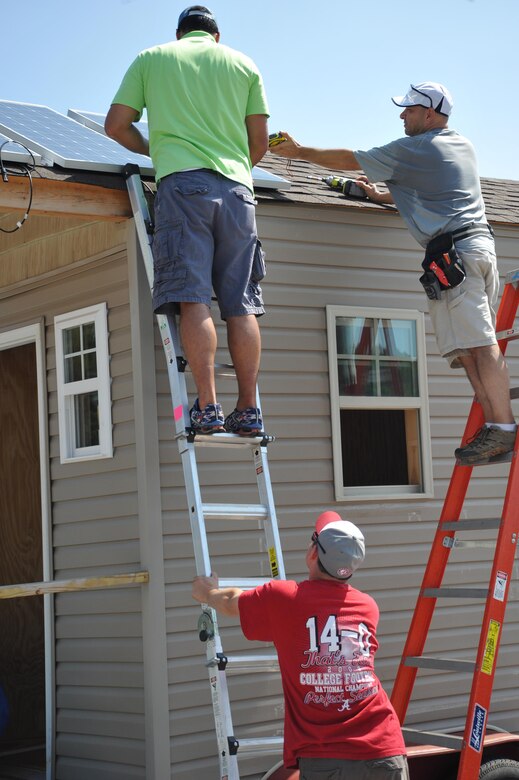 Jeffery Watts, top left, and Dominic Ragucci,bottom left, U.S. Army Engineering and Support Center, Huntsville install solar panels on tiny home August 8.