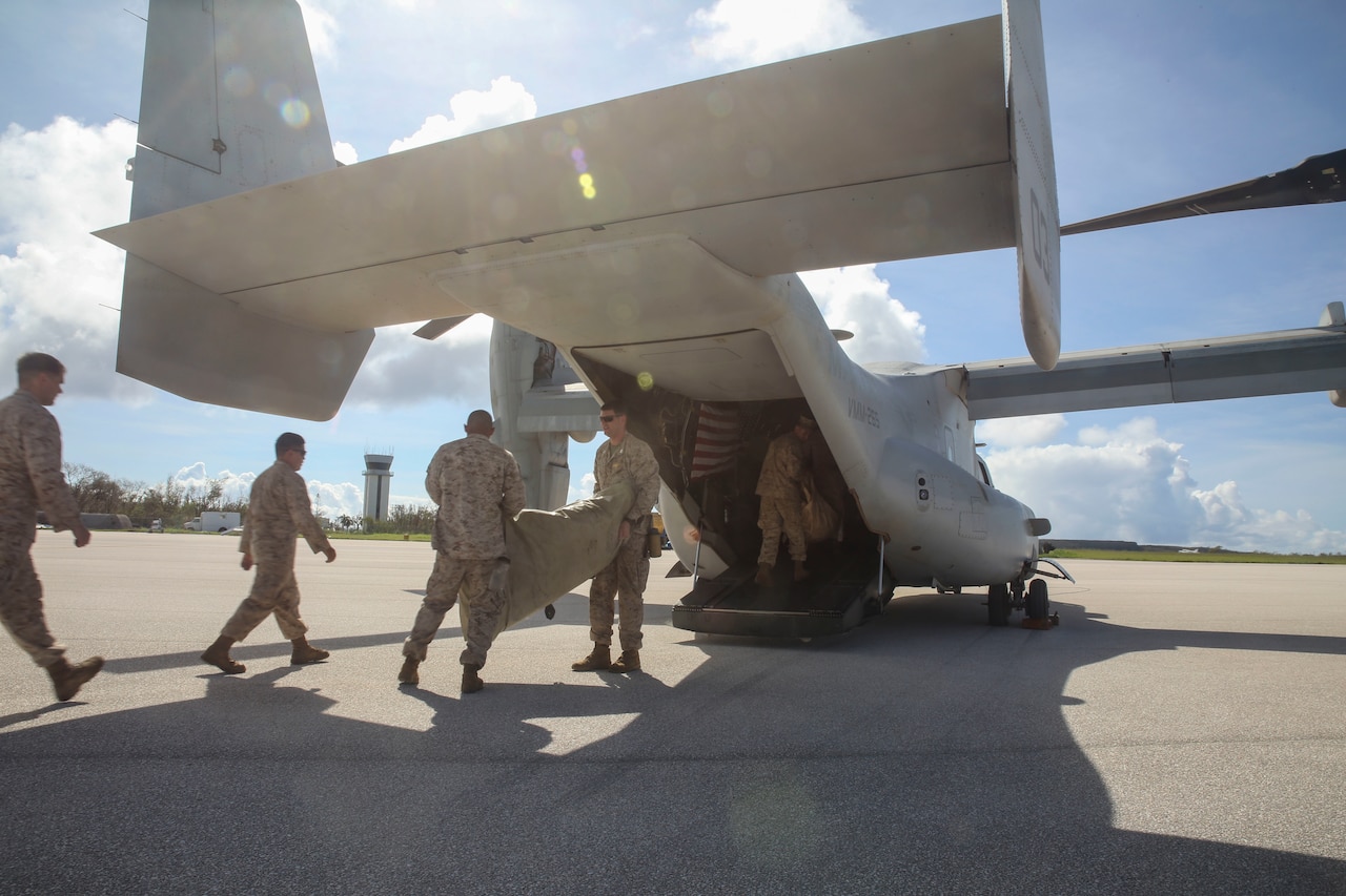U.S. Marines move water bladders out of an MV-22B Osprey at Saipan International Airport, Saipan, Aug. 9, 2015. The water bladders, able to hold 3,000 gallons, allow the distribution of water to those affected by Typhoon Soudelor, which struck the island Aug. 2-3. The Marines are assigned to Echo Company, Battalion Landing Team 2nd Battalion, 5th Marines, 31st Marine Expeditionary Unit. U.S. Marine Corps photo by Cpl. Ryan C. Mains