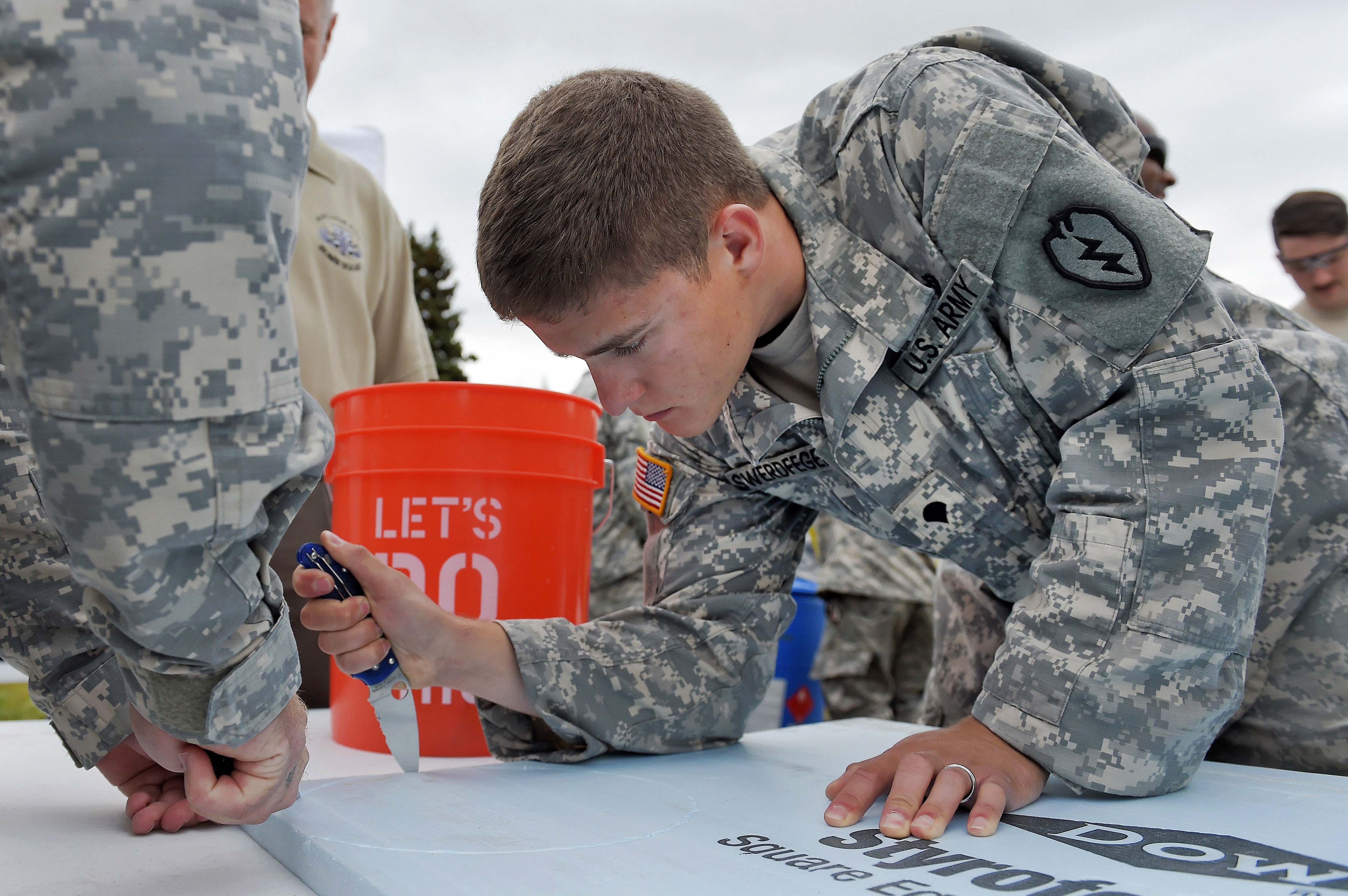 Army Spc. Matthew Swerdfeger cuts styrofoam while constructing an
