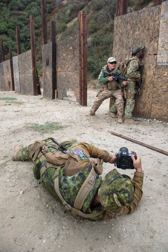 Canadian Armed Forces Master Cpl. Kevin Mcmillan, foreground, documents combatives training during Fleet Combat Camera Pacific’s Summer Quick Shot 2015 combined joint field training exercise in the Angeles National Forest near Azusa, Calif., Aug. 6, 2015. McMillan is assigned to Canadian Forces Combat Camera. 
