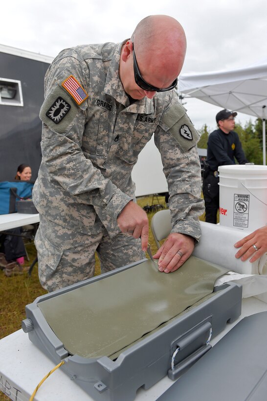 Army Staff Sgt. Clint Graves cuts a sheet of explosive charge while constructing an explosive device during explosive training on Joint Base Elmendorf-Richardson, Alaska, July 29, 2015. Graves is assigned to the 25th Infantry Division's 65th Ordnance Company, 1st Stryker Brigade Combat Team, Alaska.