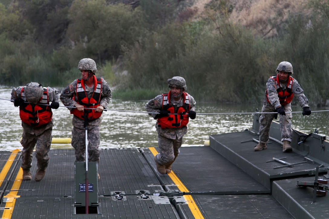 California Army National Guardsmen use a steel guide line to move a ramp and bay over Cache Creek at Cache Creek National Park in Yolo County, Calif., Aug 7, 2015.