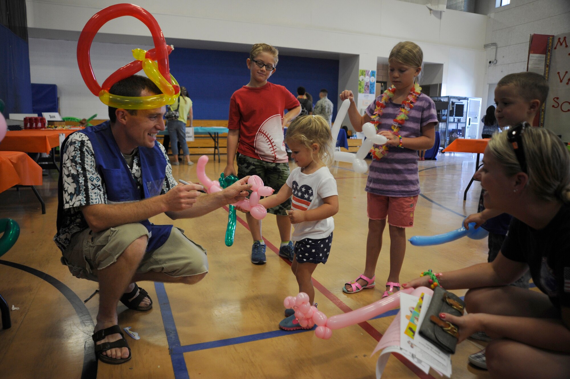 A volunteer makes balloon animals for children at the Salute to Youth event, Aug. 7, 2015, Vandenberg Air Force Base, Calif. More than 40 Team V volunteers ensured the success of the day’s events – manning a rock climbing wall, making balloon animals and preparing food for those in attendance. (U.S. Air Force photo by Airman 1st Class Robert J. Volio/Released)