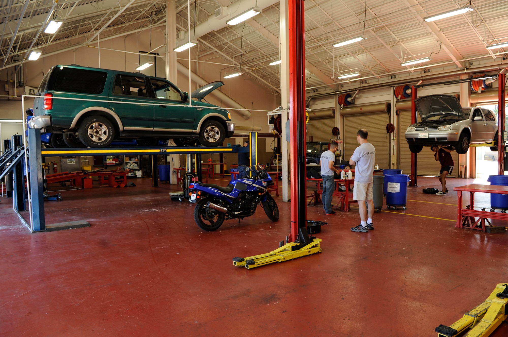 Auto Hobby Shop patrons work on their vehicles, Aug. 8, 2015, Vandenberg Air Force Base, Calif. Soon after budgetary constraints closed the facility in 2013, The Gearheads Auto Hobby Club formed, to campaign for its reopening. Following the reopening, the Gearheads have continued to support the facility by providing mechanically knowledgeable volunteers and clean-up work parties. (U.S. Air Force photo by Senior Airman Shane Phipps/Released)