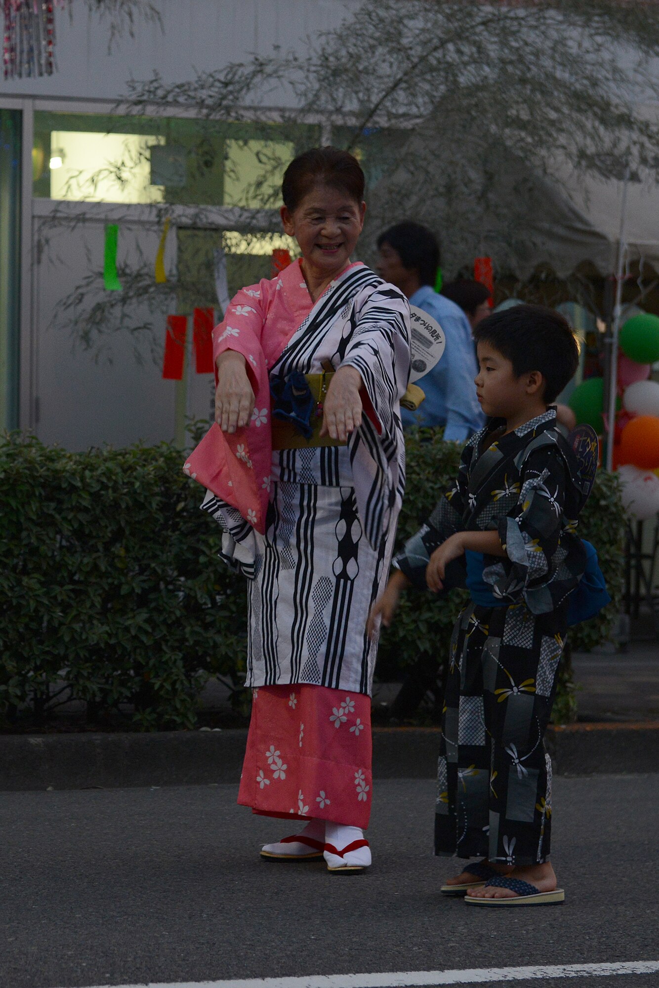 A woman teaches traditional dance steps to a child during the Tanabata Festival in Fussa City, Japan, Aug. 7, 2015. The festival included several parades as well as street vendors selling a variety of traditional Japanese festival foods. (U.S. Air Force photo by Senior Airman David C. Danford/Released)