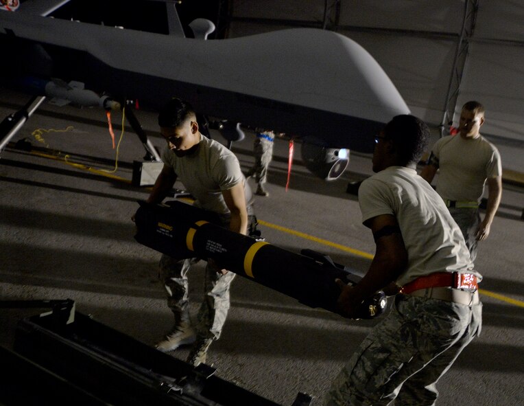Airman 1st Class Ricardo Garcia, left, and Airman 1st Class Quantavious Wall, 432nd Aircraft Maintenance Squadron weapons load crew members, lift an AGM-114 Hellfire missile Aug. 5, 2015, at Creech Air Force Base, Nevada. The load crews loaded an MQ-9 Reaper for the 2015 Air-Ground Weapons Systems Evaluation Program Combat Hammer exercise and were evaluated on timeliness, safety and accuracy of weapons loading. (U.S. Air Force photo by Airman 1st Class Christian Clausen/Released)

