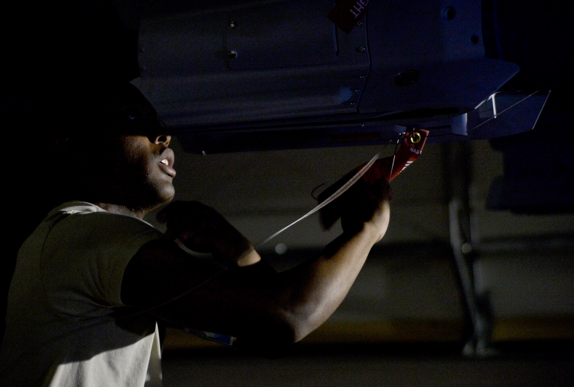 Airman 1st Class Quantavious Wall, 432nd Aircraft Maintenance Squadron weapons load crew member safety wires a GBU-12 Paveway II laser guided bomb onto an MQ-9 Reaper Aug. 5, 2015, at Creech Air Force Base, Nevada. The aircraft was loaded in preparation for the 2015 Air-Ground Weapons Systems Evaluation Program Combat Hammer exercise which operationally assesses and evaluates the reliability, maintainability, suitability, and accuracy of remotely piloted aircraft munition. (U.S. Air Force photo by Airman 1st Class Christian Clausen/Released)


