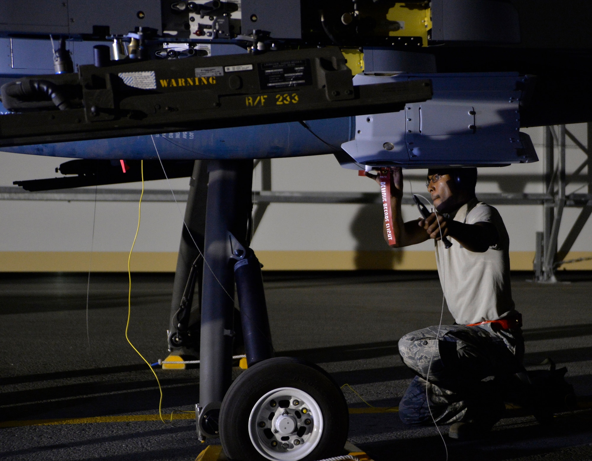 Airman 1st Class Quantavious Wall, 432nd Aircraft Maintenance Squadron weapons load crew member safety wires a GBU-12 Paveway II laser guided bomb onto an MQ-9 Reaper Aug. 5, 2015, at Creech Air Force Base, Nevada. The aircraft was loaded in preparation of the 2015 Air-Ground Weapons Systems Evaluation Program Combat Hammer exercise which operationally assesses and evaluates the reliability, maintainability, suitability, and accuracy of remotely piloted aircraft munition. (U.S. Air Force photo by Airman 1st Class Christian Clausen/Released)

