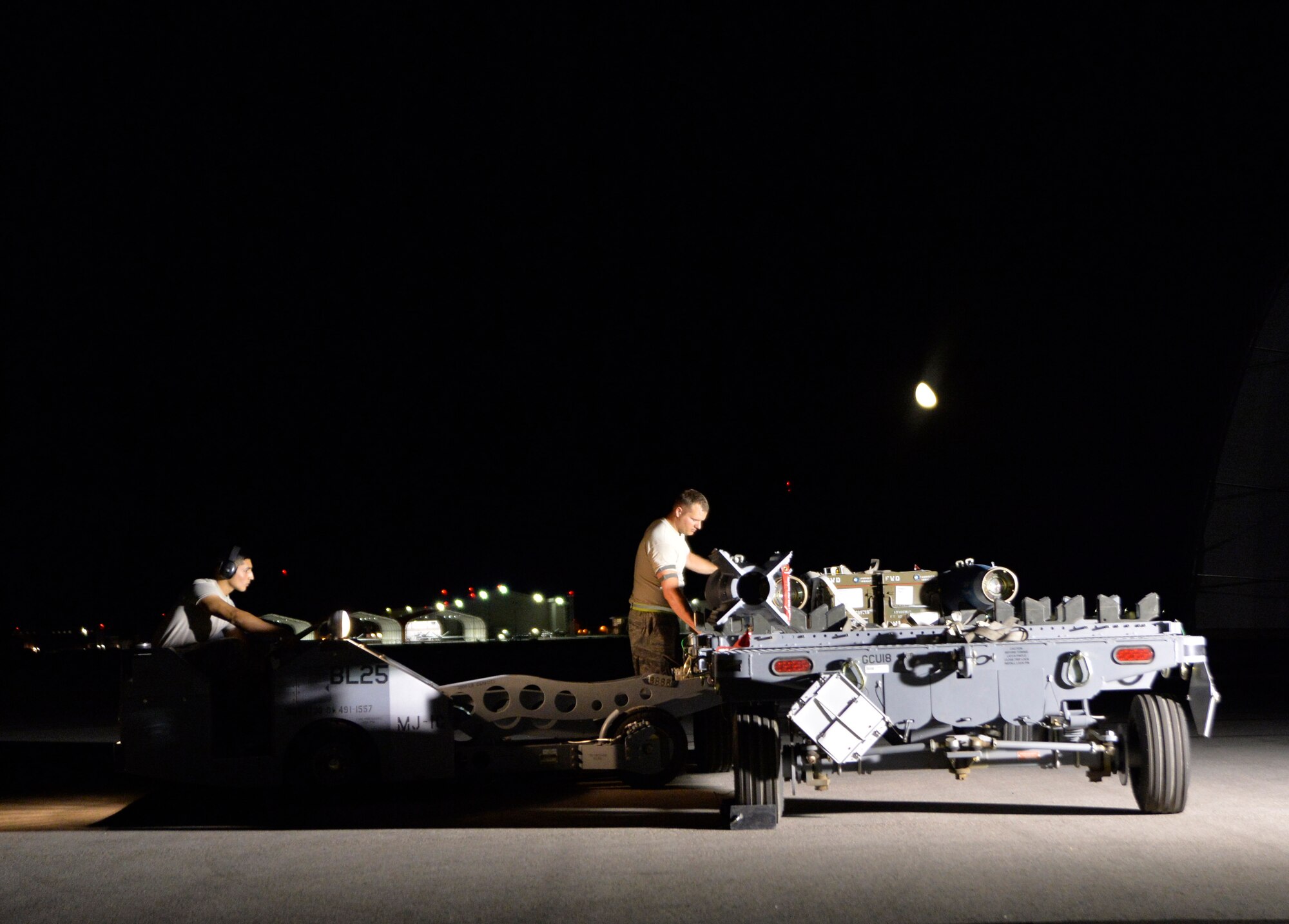 Airman 1st Class Ricardo Garcia, 432nd Aircraft Maintenance Squadron weapons load crew member, left, and Staff Sgt. Charlie Loper, 432nd AMXS load crew chief, prepare to load GBU-12 Paveway II laser-guided bombs onto an MQ-9 Reaper Aug. 5, 2015, at Creech Air Force Base, Nevada. The maintenance crews loaded the munitions in support of the 2015 Air-Ground Weapons Systems Evaluation Program exercise. (U.S. Air Force photo by Airman 1st Class Christian Clausen/Released)