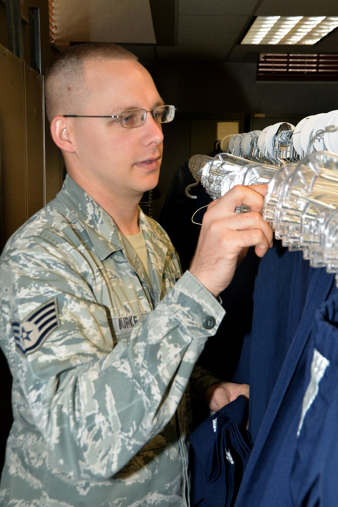 U.S. Air Force Staff Sgt. Christopher Burke’s, 55th Wing Honor Guard NCO in charge, organizes a clothing rack full of Honor Guard uniforms Aug. 7 at Offutt Air Force Base, Nebraska. Burke invested approximately $500 in organizing the uniform supply closet and has saved the Air Force more than $15,000. (U.S. Air Force photo by Dana P. Heard)