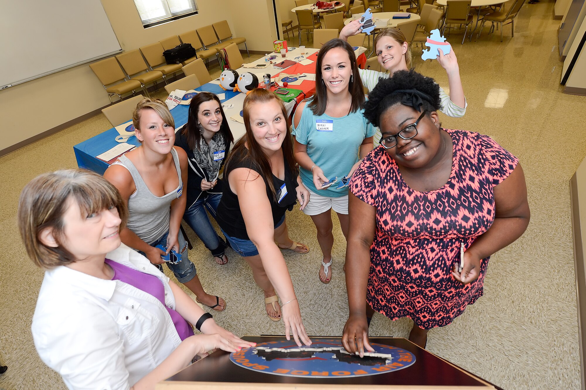 Team Dover spouses and mentors build a puzzle together while participating in Heart Link, a spouse orientation class sponsored by the Airman and Family Readiness Center and the Air Force Aid Society, July 30, 2015 at Dover Air Force Base, Del. The class included briefings on military pay and benefits, housing options and gave the group a chance to make friends and team-build through sponsored activities. (U.S. Air Force photo/Greg L. Davis)